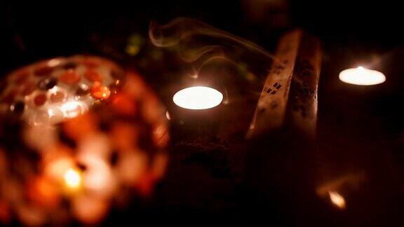 熏香和蜡烛燃烧和烟在黑暗的背景熏香和蜡烛的烟