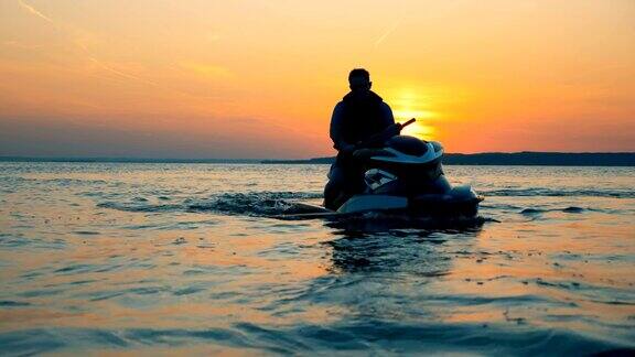 骑手坐在水上摩托艇上的夕阳背景近距离