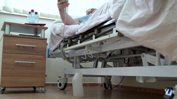 一名男子用遥控器调整病房的病床