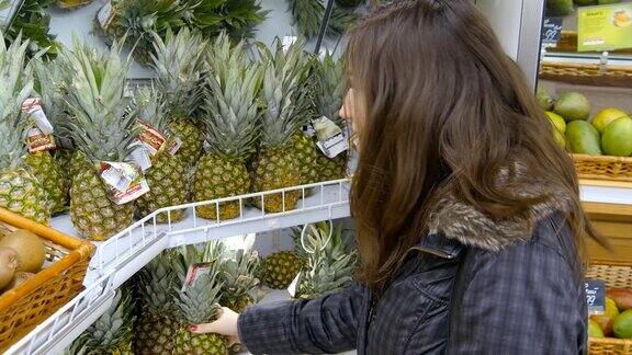 女人在超市挑选菠萝