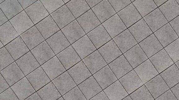 在铺有方形混凝土铺路板的广场上降落秋天