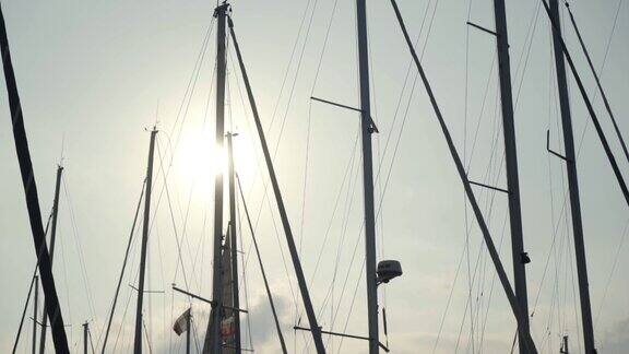 美丽的桅杆在太阳和蓝天的背景行动温暖的阳光照亮了游艇的桅杆吸引着人们去海上旅行