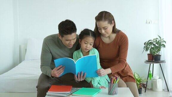 亚洲家庭父亲和母亲教女儿读书