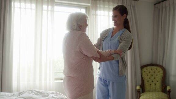 护士协助老年妇女在家行走