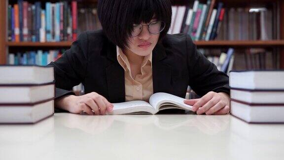 专注亚洲女学生戴眼镜在大学图书馆看书