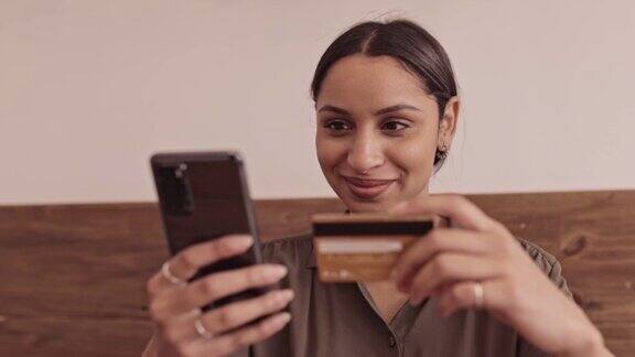一个年轻女人用智能手机付账单的4k视频