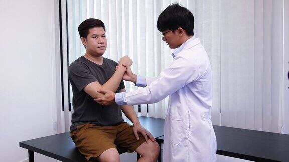 亚洲理疗师检查接受过矫形康复治疗的患者的肘部