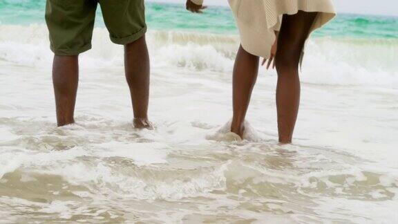 低部分的非洲裔美国夫妇玩海浪在沙滩上4k