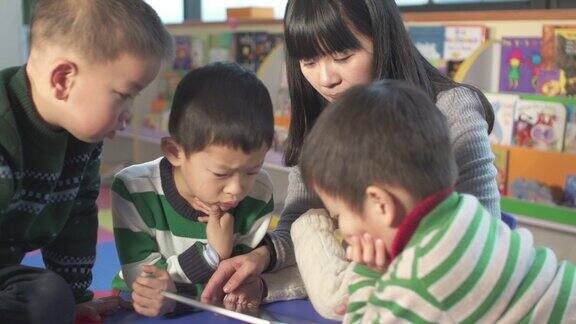 亚洲幼儿园教师用数字平板电脑教孩子