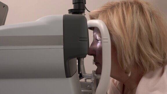眼科诊所使用专业自动屈光器进行视力检查的旋转特写视频老年人视力测试