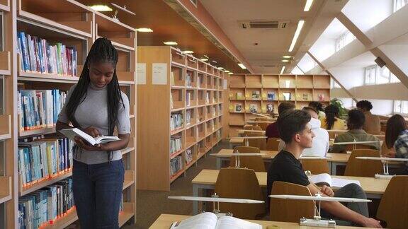 一位女学生正在现代大学图书馆里翻阅一本书