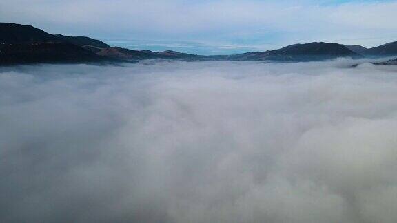 飞过山顶的云层山峰高耸清晨日出自然景观优美