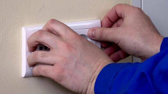 用螺丝刀将电源插座安装在墙上