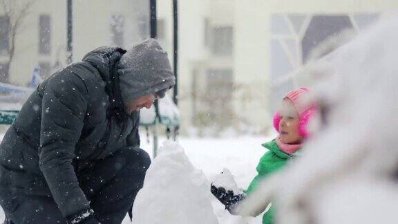 爸爸和他的孩子们在后院玩雪球爸爸和他的女儿们在外面玩雪球爸爸和他的女儿们在堆雪人两个姐妹在雪里玩一家人玩雪球寒假