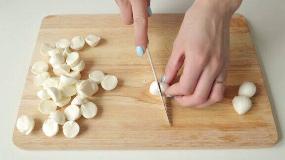 切成薄片的马苏里拉奶酪做沙拉在木板上切成两半