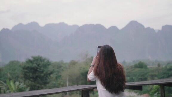 这位年轻的女游客从山顶欣赏风景