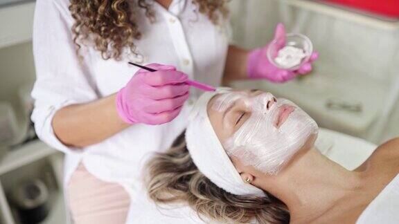 美容师用面膜刷女客户的脸