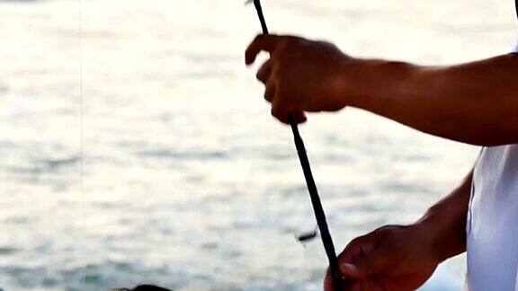 在热带海洋中钓鱼的手正在使用鱼钩