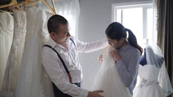 裁缝师正在测量身体的尺寸然后试穿婚纱