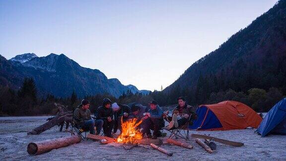 一群朋友露营坐在篝火旁