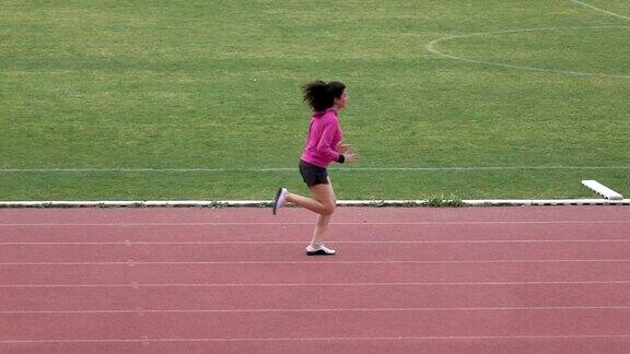 长头发的成年妇女在体育场跑步