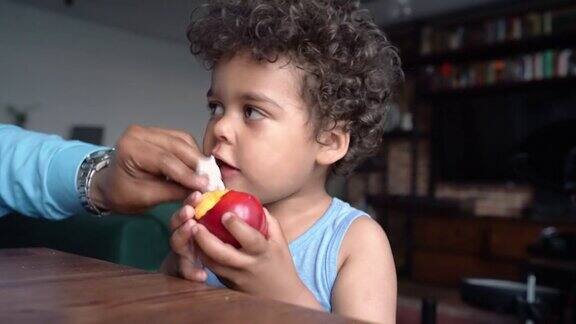 3岁的黑男孩在吃桃子