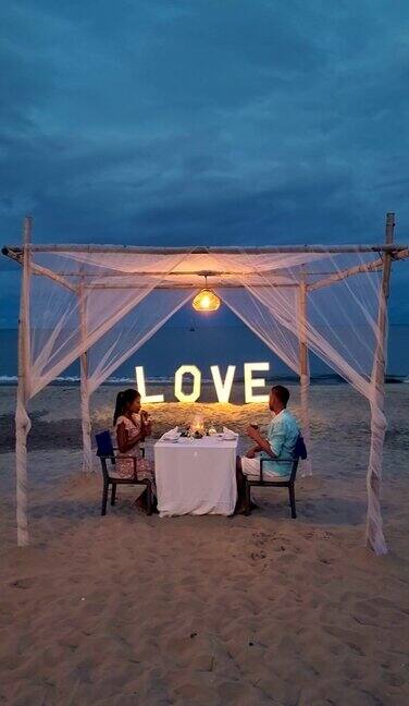 一对情侣在泰国的海滩上享受浪漫的晚餐