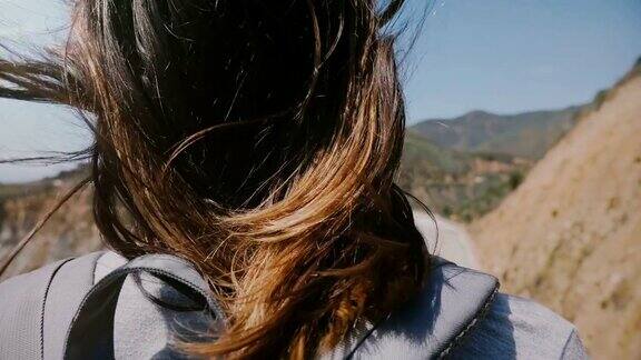 年轻的女游客与头发在强风中飞翔看史诗般的风景在比克斯比峡谷桥大苏尔