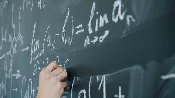 男生在黑板上写数学方程式的特写