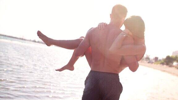 年轻浪漫的潮男背着女朋友在海滩上