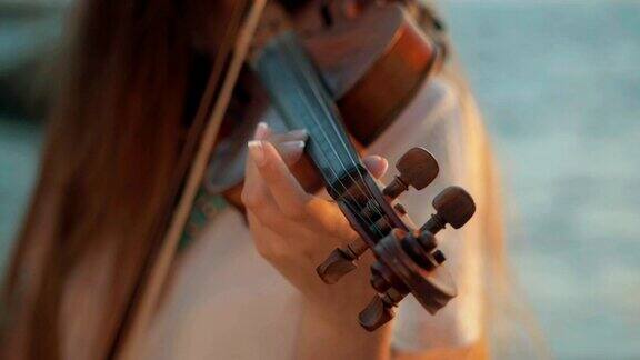 小提琴家在户外拉小提琴绿叶backgound关闭了音乐家演奏慢动作