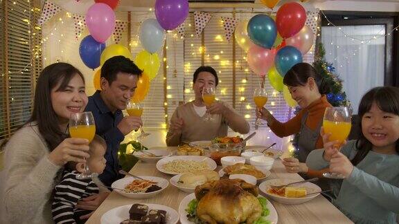 快乐的亚洲家庭在家里视频通话和享受圣诞晚餐