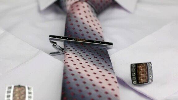 多莉特写打结的粉红色领带袖扣和领带夹上白衬衫