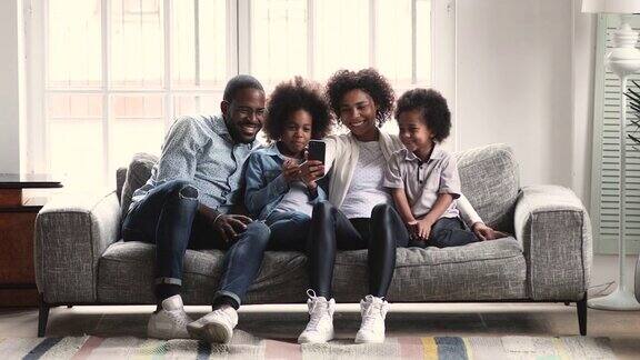 非洲父母和孩子在沙发上用手机看视频