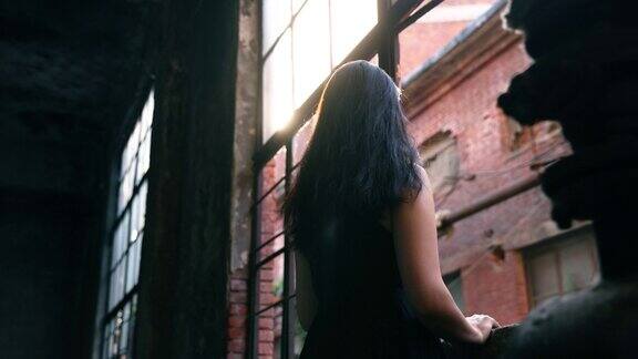 一个女人在废墟中望着窗外