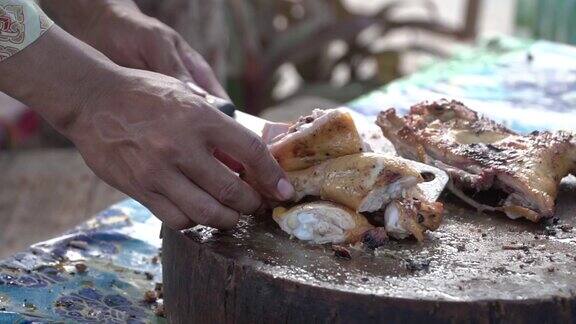 一只手把烤鸡剁在剁好的木块上皮肤油腻是健康食品