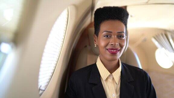 商务飞机上微笑的女商人看着镜头的肖像