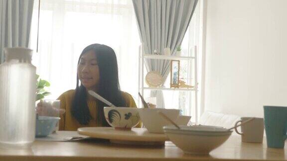 亚洲女孩穿着黄色毛衣在家享受美食隔离生活理念