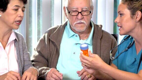 西班牙护士向一对老年夫妇解释药物