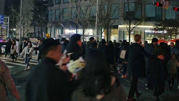 人群走在繁忙的购物街在韩国城市生活的夜晚