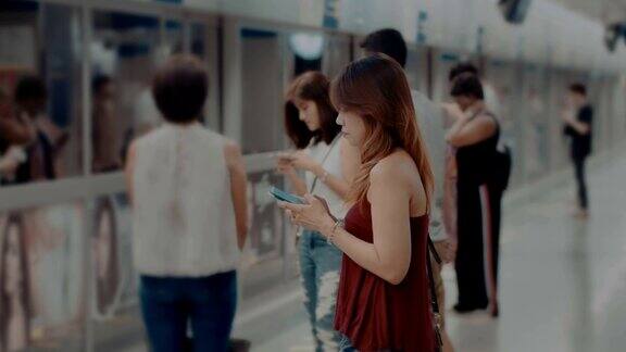 一个亚洲女人在地铁站发短信