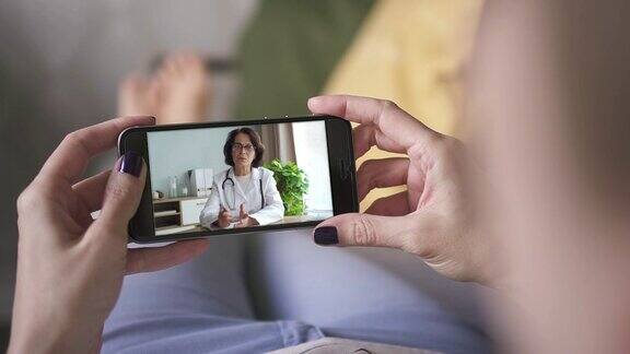 女人通过智能手机视频电话与医生交谈在线医疗咨询