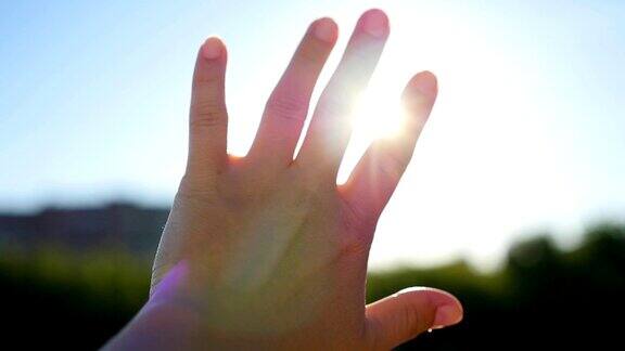 他手中的太阳女人用手抓住太阳的背景上美丽的日落在地平线上大自然