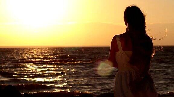 快乐的女人放松在海边日落