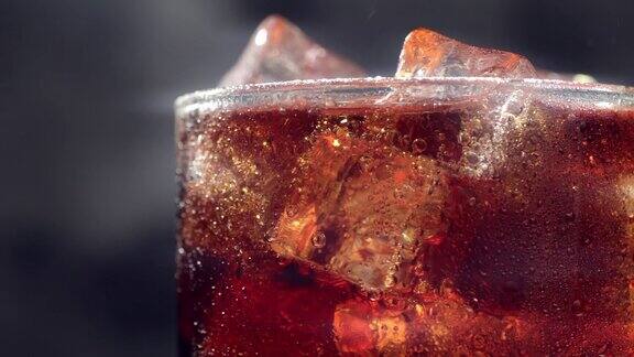 微距慢镜头玻璃与冰块和气泡的新鲜碳酸可乐苏打饮料近