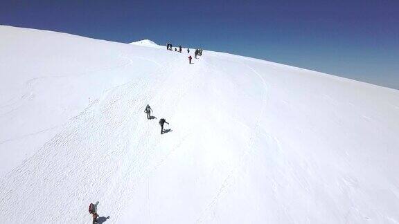 从上面看旅游团在雪山步道上行走冬天的山