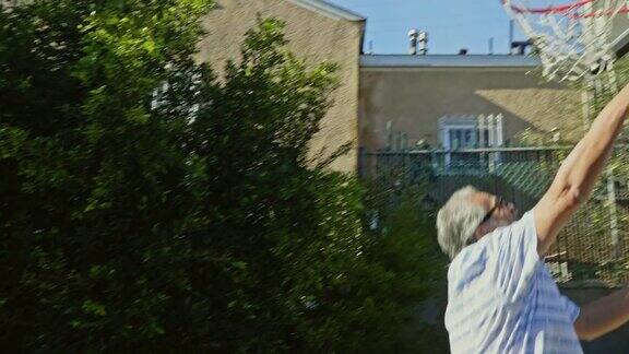 西班牙裔老人在后院打篮球的慢动作视频