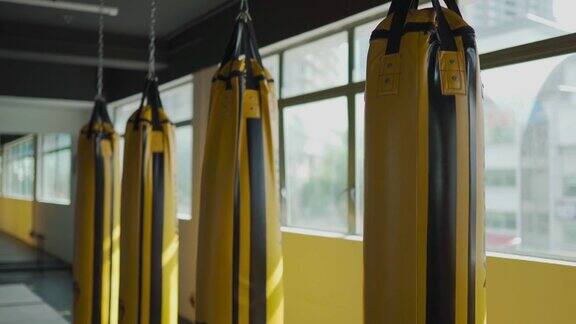 健身房健身俱乐部窗户旁有一排黄色沙袋沙袋是白天的时间