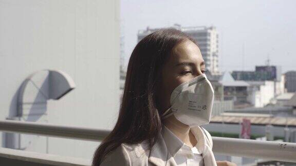亚洲女性要去工作她戴着N95口罩防止PM2.5粉尘和雾霾