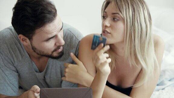欢快的年轻夫妇在网上购物使用数字平板电脑信用卡